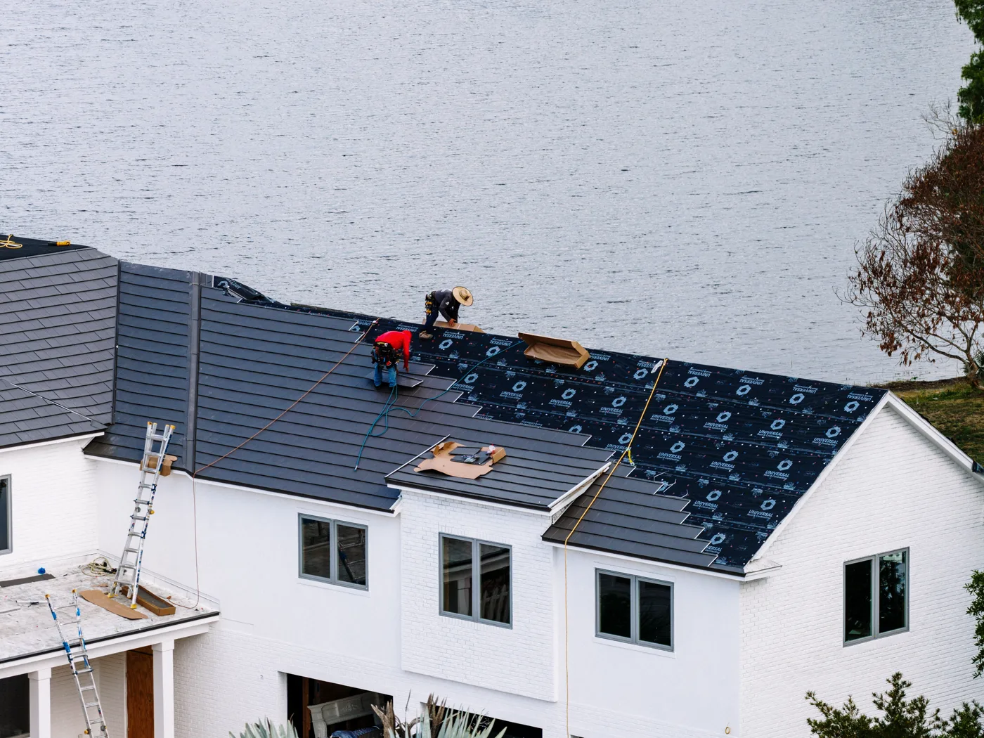A Metlok crew installing a new roof on a waterfront home